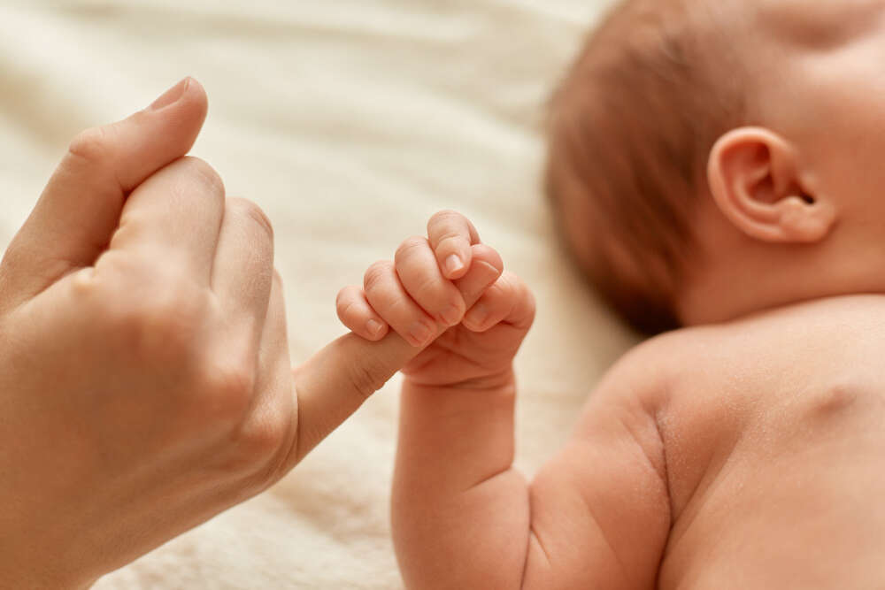 Main adulte et main de bébé