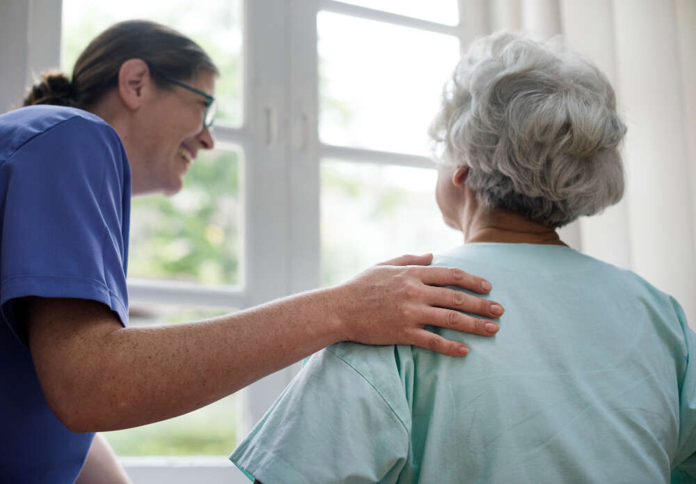 Infirmière aidant une personne âgée de dos